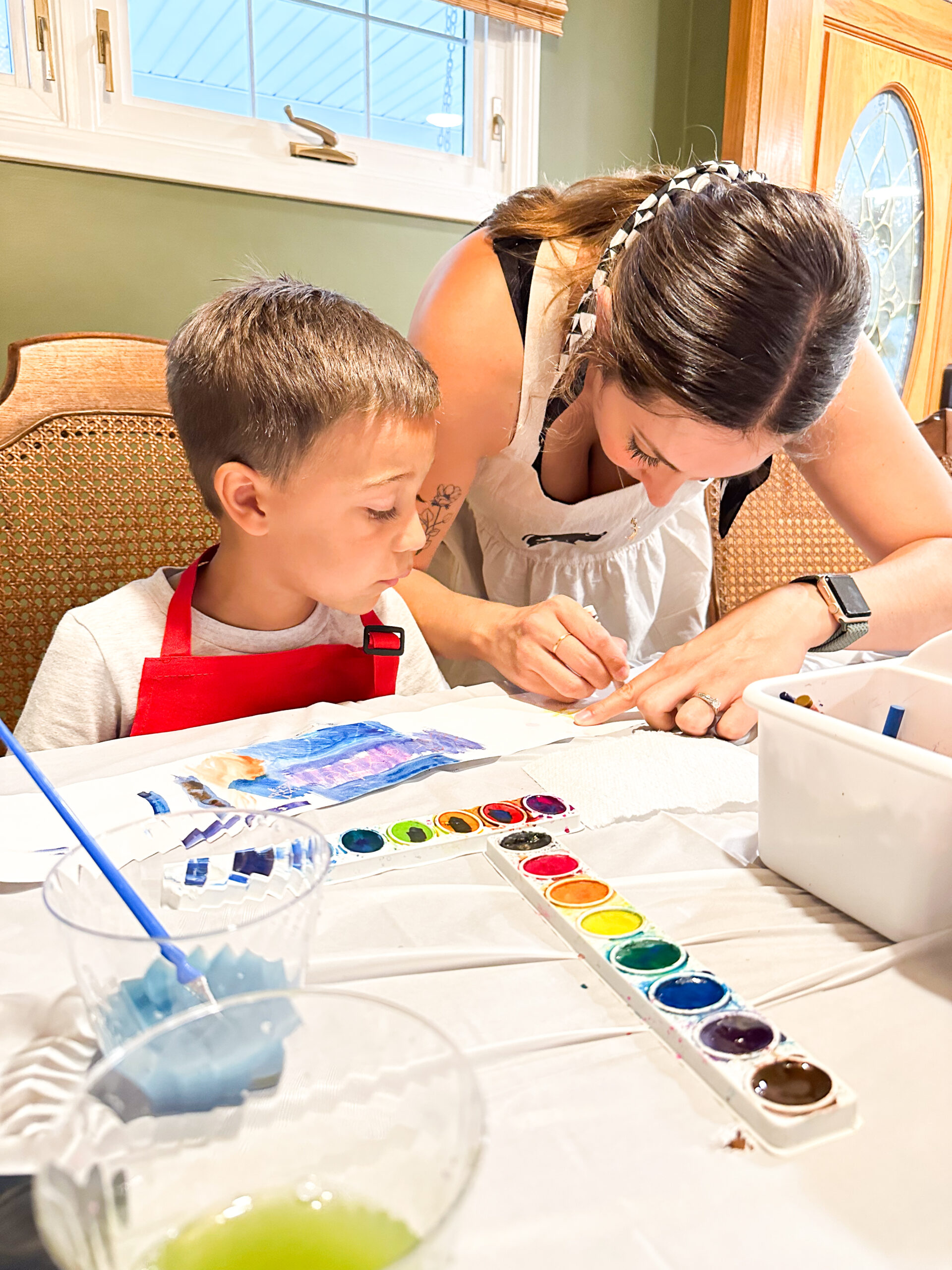 Caroline assists child with the fitting of their paper crown craft